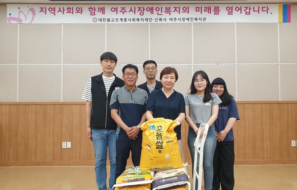 기증한 쌀과 함께 한 여주시장애인복지관 직원들.