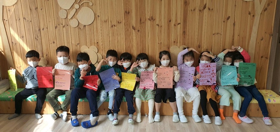 경기도 김포시립 e-꿈찬어린이집 원생들이 코로나19 의료진들을 응원하는 위문편지를 작성한 후 들어보이고 있다.
